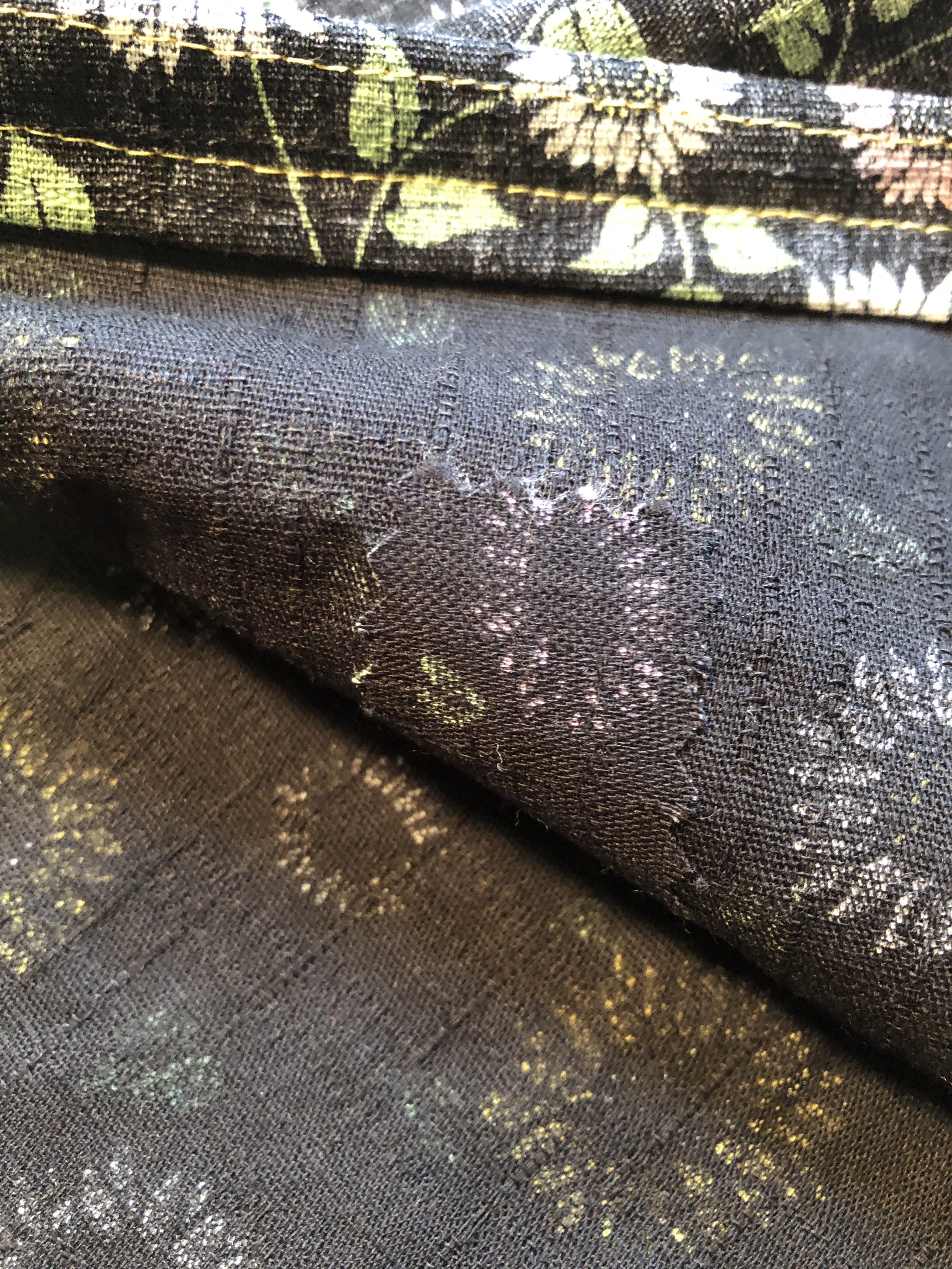 a gray floral print fabric's wrong side with a small patch of the same fabric adhered to it